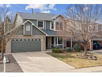 Charming two-story home with a well-maintained lawn, brick accents, and an attached two-car garage at 5209 S Zeno Way, Aurora, CO 80015