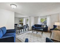 Bright living room featuring modern furniture, a dining area, and ample natural light at 2826 S Lansing Way, Aurora, CO 80014
