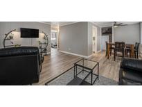 Open living space with wood floors, modern lighting, and access to dining and bedroom at 10115 W 25Th Ave # 1, Lakewood, CO 80215