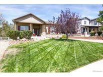 Charming single-Gathering home featuring manicured lawn, stone accents, and a welcoming covered front porch at 3419 Traver Dr, Broomfield, CO 80023