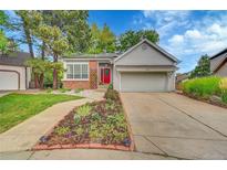 Inviting single Gathering home showcasing a well-kept lawn, solar panels, and a red front door at 7975 S Gaylord Way, Centennial, CO 80122