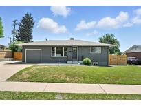 Charming home featuring well-maintained lawn, gray brick exterior, and attached garage at 2714 S Raleigh St, Denver, CO 80236