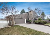 Two story home featuring a stone facade, neutral toned wood siding, and an attached two car garage at 1585 W Briarwood Ave, Littleton, CO 80120