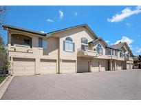 Charming townhome exterior with attached garages and well-maintained landscaping under a bright blue sky at 8777 E Dry Creek Rd # 1426, Englewood, CO 80112
