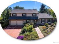 Two-story house with a brick facade, attached two-car garage, and landscaped yard at 1866 W Davies Ave, Littleton, CO 80120