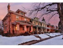 Brick homes line a snow-covered street, showcasing classic architecture and inviting front porches at 1586 Steele St, Denver, CO 80206