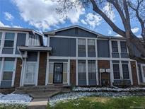 Charming townhome featuring a well-maintained exterior with brick accents and a welcoming front entrance at 155 Paris Cir, Aurora, CO 80011