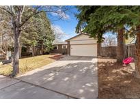 Charming exterior view of home, showcasing a spacious driveway, two car garage and partial lawn at 15104 E Utah Pl, Aurora, CO 80012