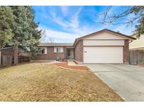 Charming brick home with a two-car garage and a well-manicured lawn on a sunny day at 15104 E Utah Pl, Aurora, CO 80012