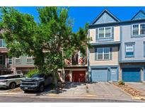 Attractive townhome with colorful facade, red garage door, and a tree in front at 12043 E Ford Cir, Aurora, CO 80012
