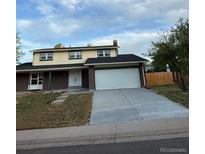 Two-story home featuring a two-car garage and a well-maintained lawn at 8694 E Eastman Ave, Denver, CO 80231