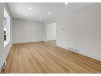 Bright living room featuring hardwood floors, recessed lighting and a large window providing ample natural light at 8694 E Eastman Ave, Denver, CO 80231