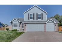 Charming two-story home with light blue siding, a well-kept lawn, and an attached two-car garage at 2195 S Espana St, Aurora, CO 80013