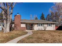 Charming single-story home with a red brick chimney and walkway leading to the front door at 2061 E Floyd Ave, Englewood, CO 80113