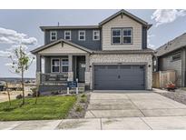 Inviting two-story home boasting a stylish mix of siding and brick, complemented by a well-manicured lawn and a spacious driveway at 13812 Honey Hush Trl, Parker, CO 80134