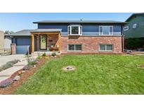 Charming two-story home with a well-manicured lawn and inviting brick and blue exterior at 3491 Kassler Pl, Westminster, CO 80031