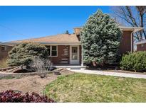Charming brick home with a manicured lawn, mature trees, and inviting walkway at 6305 Yukon St, Arvada, CO 80004