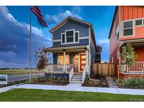 Charming blue two-story home with a red front door and covered porch, creating a welcoming curb appeal at 6309 N Hanover St, Denver, CO 80238