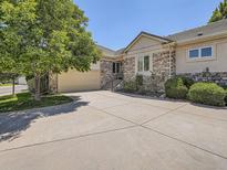 Charming home with a stone facade, two-car garage, and a well-manicured front yard at 14064 E Whitaker Dr, Aurora, CO 80015