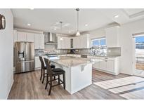 Modern kitchen with stainless steel appliances, granite countertops, and a large center island at 16278 E 111Th Pl, Commerce City, CO 80022