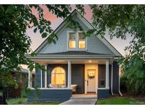 Charming home with a painted brick exterior, covered porch, and manicured front yard at 2515 Zenobia St, Denver, CO 80212
