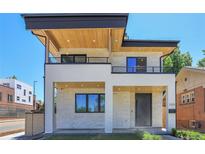 Modern two-story home with stone facade, black trim, wood soffits and dual balconies at 300 S Franklin St, Denver, CO 80209