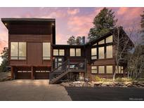 Stunning two-story home with wood siding, two-car garage, and picturesque front entrance at 8453 S Scenic Dr, Morrison, CO 80465