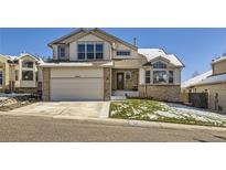 Charming two-story home with brick accents, attached garage, and well-maintained lawn on a sunny day at 6464 S Swadley Way, Littleton, CO 80127