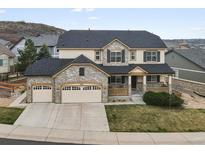 Charming two-story home with a three-car garage, stone accents, and a cozy front porch at 2463 Tavern Way, Castle Rock, CO 80104