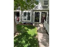 Charming townhome featuring a well-maintained lawn, concrete walkway, and gray siding with decorative trim at 2285 S Jasper Way # A, Aurora, CO 80013