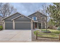 Charming two-story home featuring a three car garage, well-maintained lawn, and decorative trees in a Gathering-friendly neighborhood at 1521 Redtail Ct, Longmont, CO 80504