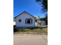 Charming single-story home with white siding, a blue trim, and a detached garage at 521 10Th St, Fort Lupton, CO 80621