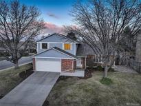 Charming home with brick accents, a well-manicured lawn, and a two-car garage at 4604 S Xavier St, Denver, CO 80236