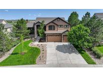 Beautiful two-story home featuring stone accents, a three-car garage, and professionally landscaped yard at 6078 Bridle Path Ln, Parker, CO 80134