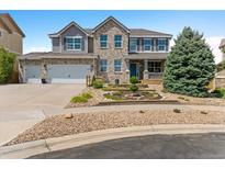 Charming two-story home with a well-maintained lawn, brick accents, and a two-car garage and inviting front porch at 11921 S Black Horn Cir, Parker, CO 80134