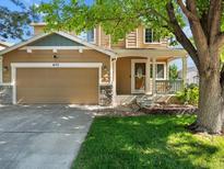 Charming two-story home with a covered front porch, two-car garage, and a well-maintained lawn at 4111 W Kenyon Ave, Denver, CO 80236