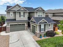 Charming two-story home with stone accents, a well-manicured lawn and a three car garage at 7099 E 123Rd Pl, Thornton, CO 80602