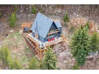 Charming A-frame cabin with an expansive deck nestled in a serene mountain setting with a hot tub at 352 Apache Rd, Evergreen, CO 80439