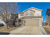 Two-story house with tan and brown siding, attached garage, and a well-maintained front yard at 10699 Durango Pl, Longmont, CO 80504