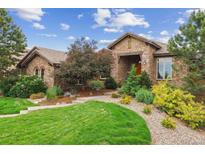 Charming stone home with a well-manicured lawn and beautiful landscaping at 4651 Sonado Pl, Parker, CO 80134