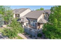Charming townhome with stone accents, a private balcony, and lush landscaping at 3985 W 104Th Dr # E, Westminster, CO 80031