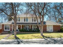 Charming two-story home with a brick facade, well-manicured lawn, and mature trees in a desirable neighborhood at 10748 E Dorado Pl, Englewood, CO 80111