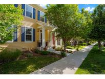 Charming home featuring a covered porch, yellow siding and contrasting blue shutters at 8427 E 35Th Ave, Denver, CO 80238