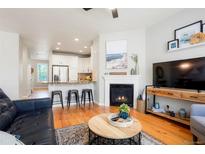 Inviting living room featuring an open-concept layout with a fireplace and breakfast bar seating at 8427 E 35Th Ave, Denver, CO 80238