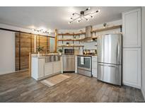 Modern kitchen features stainless appliances, floating shelves, and stylish lighting fixtures at 1625 Larimer St # 3004, Denver, CO 80202