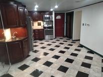 A spacious kitchen featuring dark wood cabinets and black-and-white checkered tile flooring at 8822 E Florida Ave # G07, Denver, CO 80247