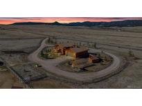 Expansive property featuring a charming rustic home and barn with mountain views in the background at 11524 Spruce Mountain Rd, Larkspur, CO 80118