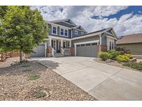 Charming two-story home with a three-car garage, landscaped front yard, and a concrete driveway at 9527 Iron Mountain Way, Arvada, CO 80007