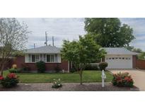 Charming single-story brick home with a well-manicured lawn, colorful flowers, and an attached two-car garage at 1820 W 104Th Pl, Northglenn, CO 80234