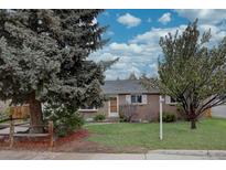 Charming brick home featuring a well-maintained front yard with mature trees under a bright sky at 4391 W Tufts Ave, Denver, CO 80236